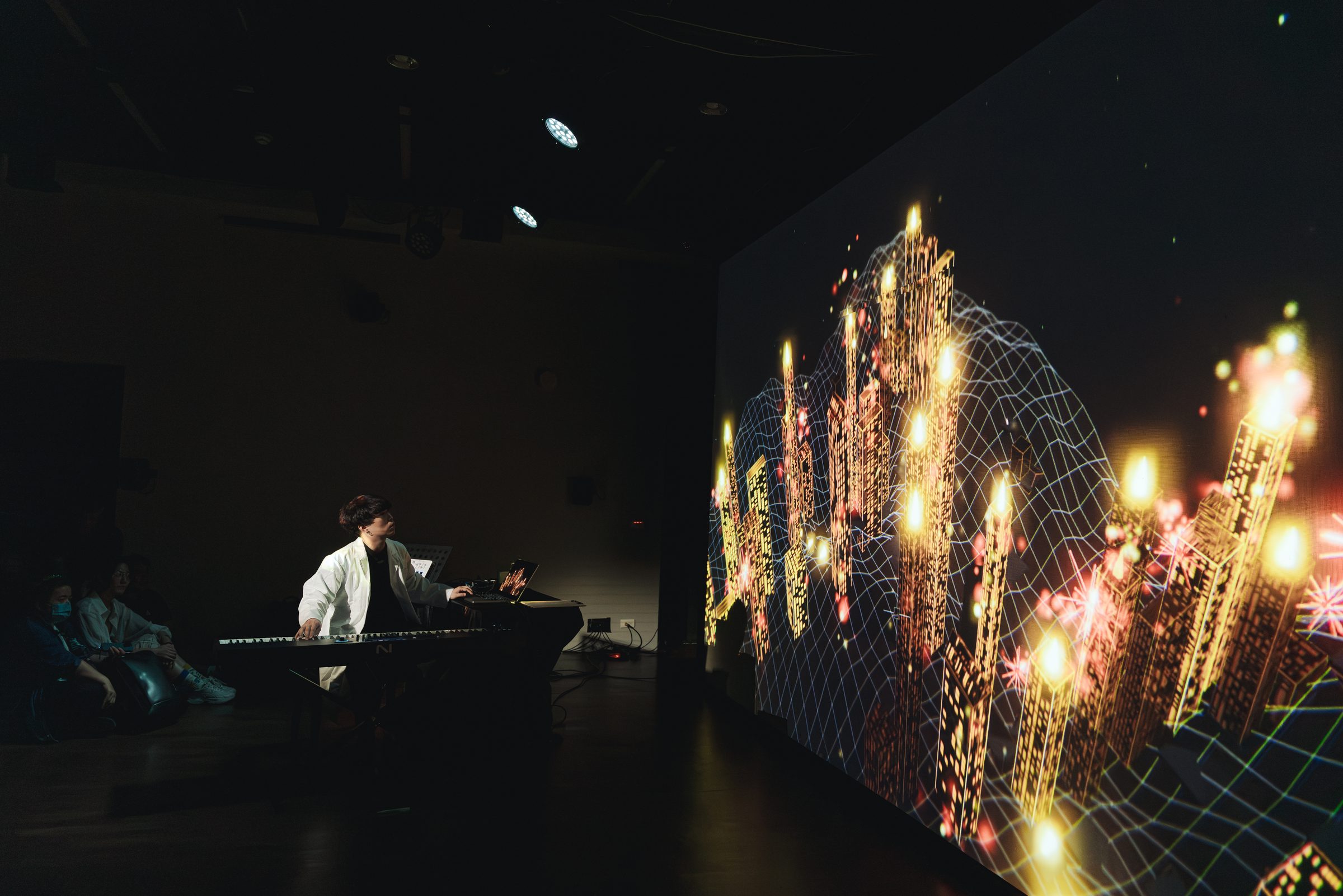 Che-Yu Wu performs at the piano beside a projection of a generative city